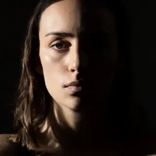 A portrait with dramatic split lighting — half the face brig