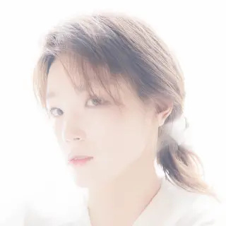 A high-key portrait of a person against a bright white backg