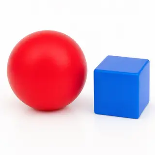 A red ball and a blue cube sitting side by side on a white s