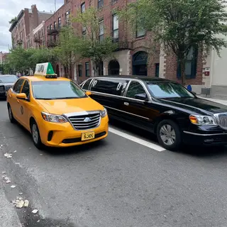 A yellow taxi and a black limousine parked next to each othe