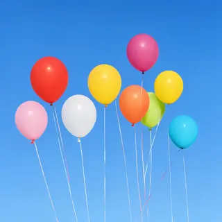 Exactly 11 colorful balloons floating against a clear blue s