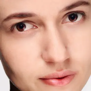 A human face with eyes, nose, and mouth but no eyebrows