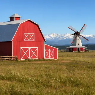 A landscape with a red barn in the foreground at large scale