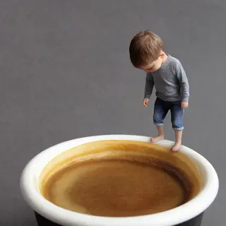 A tiny person standing on the rim of a coffee cup, looking d