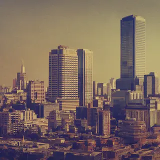 A cityscape rendered in nostalgic futurism — retro-futuristi