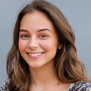 A close-up portrait of a young woman with a warm natural smi