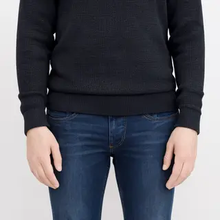 A person standing with both hands visible at their sides, fi