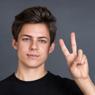 A person making a peace sign with their right hand, clearly 