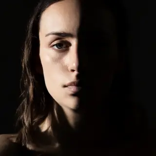 A portrait with dramatic split lighting — half the face brig