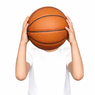 A child holding a basketball, both at correct relative sizes