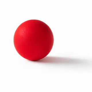 A red sphere on a white surface with a single shadow cast to