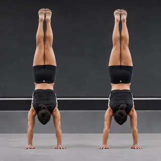 Two gymnasts performing a synchronized handstand, side by si