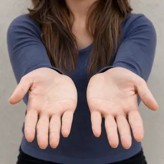 A woman holding her hands out in front of her palms-up, all 