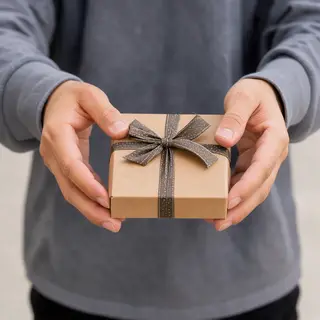 One person handing a small gift box to another person, both 