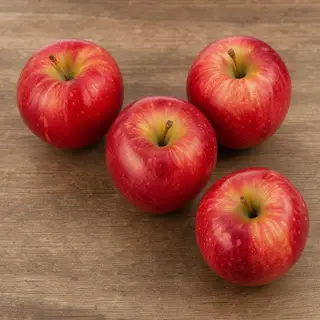 Exactly 3 red apples arranged on a wooden table