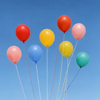 Exactly 11 colorful balloons floating against a clear blue s
