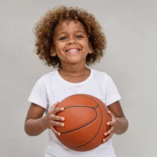 A child holding a basketball, both at correct relative sizes