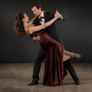 Two tango dancers in a close embrace, the man dipping the wo