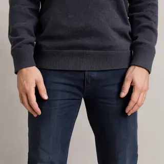 A person standing with both hands visible at their sides, fi