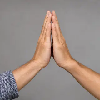 Two people doing a high-five, palms meeting with all fingers