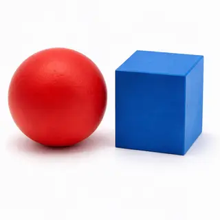 A red ball and a blue cube sitting side by side on a white s