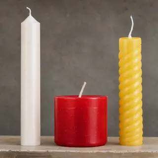 A tall thin white candle, a short fat red candle, and a medi