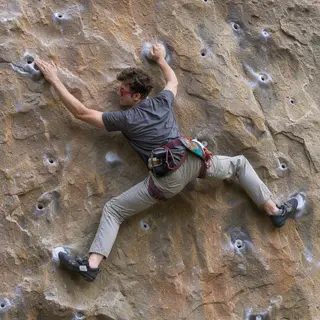 A rock climber clinging to a cliff face with arms and legs e