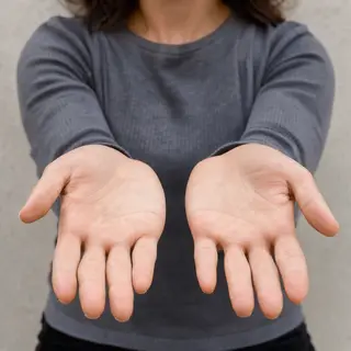 A woman holding her hands out in front of her palms-up, all 