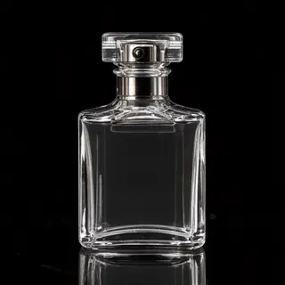 A clear glass perfume bottle on a reflective black surface w
