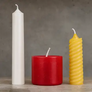 A tall thin white candle, a short fat red candle, and a medi