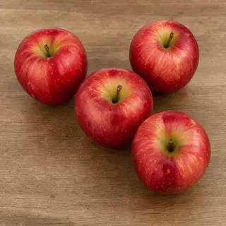 Exactly 3 red apples arranged on a wooden table