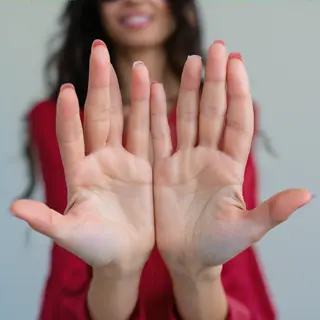 A woman holding her hands out in front of her palms-up, all 