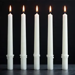 Exactly 4 white candles standing on a dark surface
