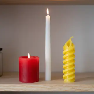 A tall thin white candle, a short fat red candle, and a medi