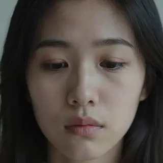 A face showing quiet melancholy — downcast eyes, slightly dr