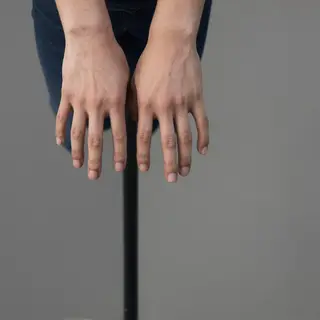 A person standing with both hands visible at their sides, fi