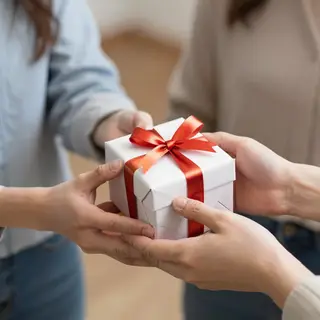 One person handing a small gift box to another person, both 