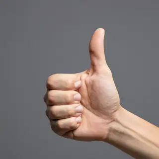 A hand giving a thumbs-up with four fingers curled and thumb
