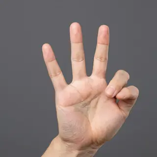 A person counting to three on their fingers, with index, mid