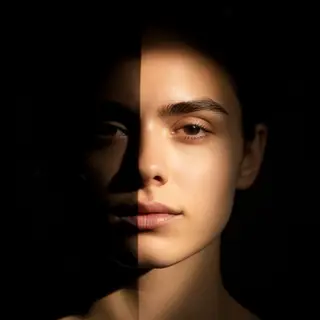 A portrait with dramatic split lighting — half the face brig