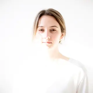 A high-key portrait of a person against a bright white backg