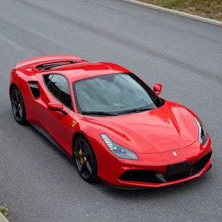 A bright red sports car parked on a gray asphalt road — the 