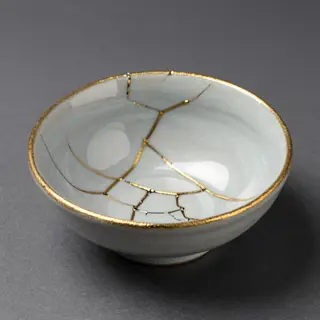 A Japanese kintsugi bowl — cracked ceramic repaired with vis