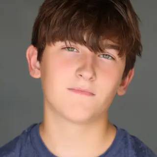 A headshot of a teenager with a relaxed, neutral face