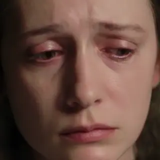 A face showing quiet melancholy — downcast eyes, slightly dr