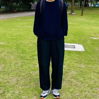A person standing in a neutral pose in a park, full body vis