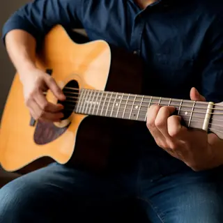 A person playing an acoustic guitar with left hand on the fr