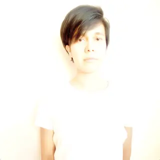 A high-key portrait of a person against a bright white backg
