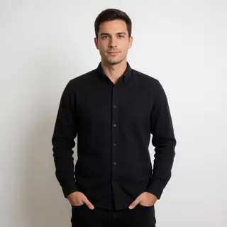 A man standing straight facing the camera, hands in pockets,