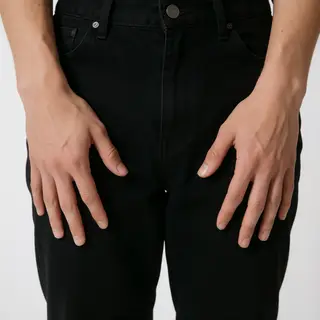A person standing with both hands visible at their sides, fi